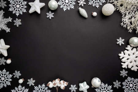 Christmas holidays composition with white christmas decorations and snowflakes on black background with copy space for your textの写真素材