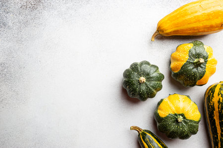 Autumn background: pumpkins and fallen leaves on white background. Top view and copy space. Thanksgiving dayの写真素材