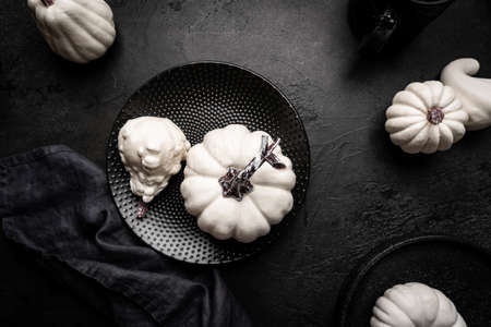 Creative flat lay autumn composition. Pumpkins over black background, top view. Template fall, thanksgiving or halloween cardsの写真素材