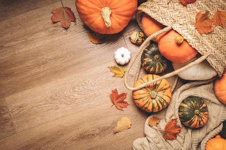 Autumn composition with pumpkins, dried leaves on wooden background. Autumn, fall, halloween concept. Flat lay, top view, copy spaceの写真素材