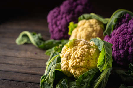 Raw fresh colorful cauliflowers on a dark wooden background. Healthy eatingの写真素材