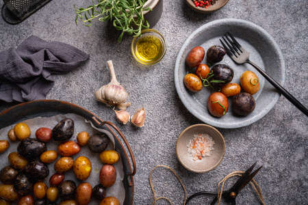 Various varieties of baked new colorful, white, red and purple potatoes on gray background, top viewの写真素材