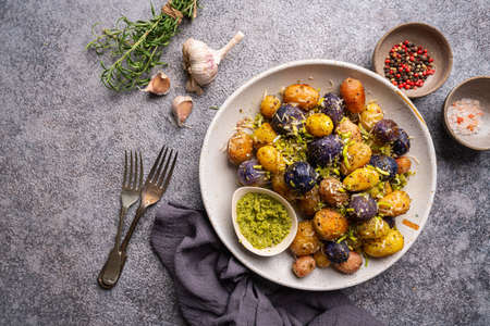 New roasted, baked baby potato on the plate with sauce, top viewの写真素材