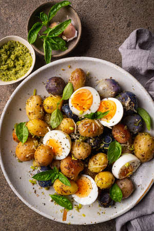 Homemade salad of new colorful potatoes, quail eggs and pesto, top viewの写真素材