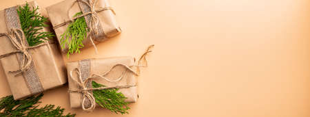 Christmas gift or present box wrapped in kraft paper with decoration on gold or champagne...