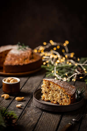 Traditional Christmas cake pudding with fruits and nuts with Christmas decorations, dark backgroundの写真素材