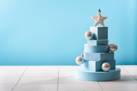 Christmas tree made of blue geometric shapes and podiums on blue backgroundの写真素材