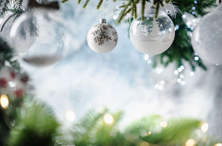 Christmas decoration with white christmas balls and fir tree branches against blurred blue background, copy space for your product or text.の写真素材