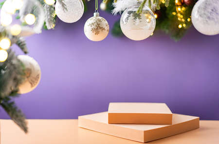 Christmas decoration with white christmas balls and fir tree branches against blurred purple background, copy space and geometric shapes podiums for your product or text.の写真素材