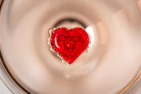 Valentines Day background or greeting card. Red hearts inside glass of champagne close up with free spaceの写真素材