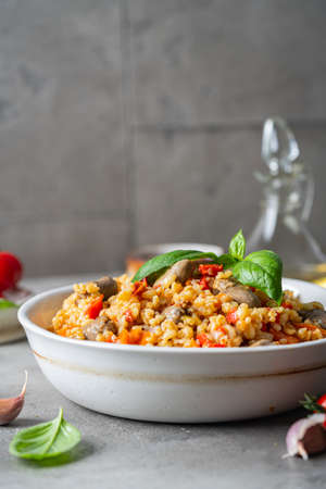 bulgur with chicken hearts and vegetables. Delicious healthy dish on a gray background. Bulgur pilaf