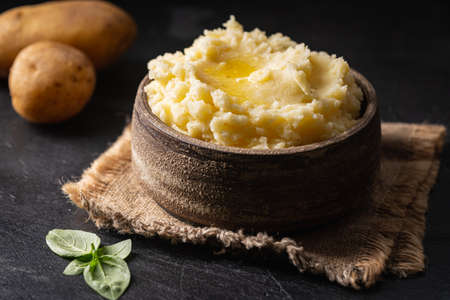 Mashed potatoes in ceramic bowl on wooden rustic table. Healthy food