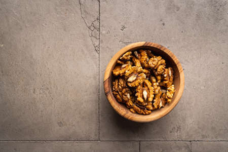 walnut nuts in a bowl on gray stone background top view with copy space. Healthy snack food.の写真素材