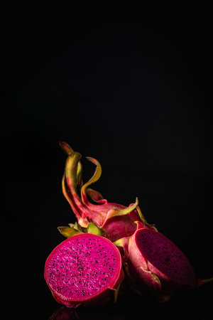 Ripe fresh red Dragon fruit or pitaya with slice part on black backgroundの写真素材