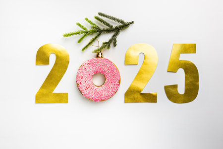 Christmas banner with toy glazed donut and gold 2021 numbers, top view. white background.