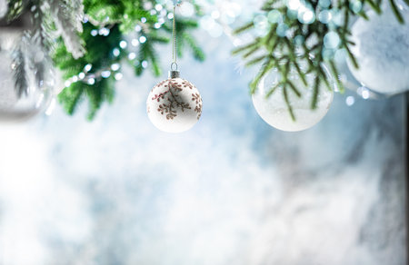 Christmas decoration with white christmas balls and fir tree branches against blurred blue background, copy space for your product or text.の写真素材