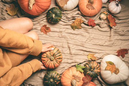 autumn background with woman sitting between pumpkins, top viewの写真素材