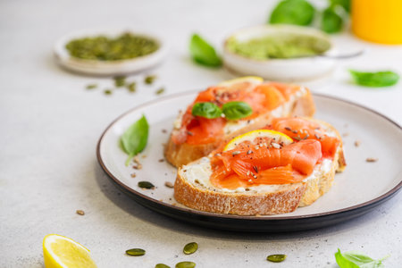 Sandwich with ricotta (cream cheese), smoked salmon and micro greens served on white background. Health care, super food concept.の写真素材