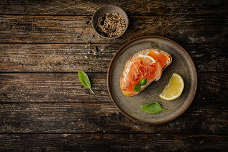 Sandwich with ricotta (cream cheese), smoked salmon and micro greens served on wooden background. Top view.の写真素材