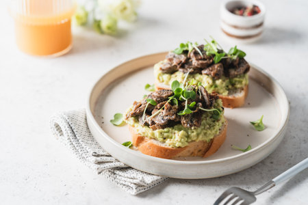 Toast avocado, mushrooms and microgreens whole grain sandwich. Vegetarian food. Delicious breakfast or snack, Clean eating, dieting, vegan food concept.の写真素材