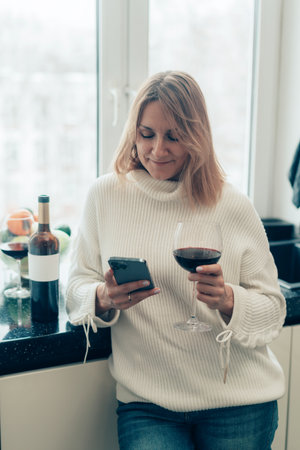 woman with wine and smartphoneの写真素材