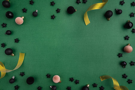 Black Ornaments and Stars Frame with Gold Ribbon on Greenの写真素材