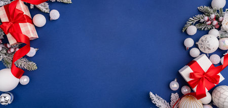 White Christmas Gift with Red Ribbon and Ornaments on Blueの写真素材