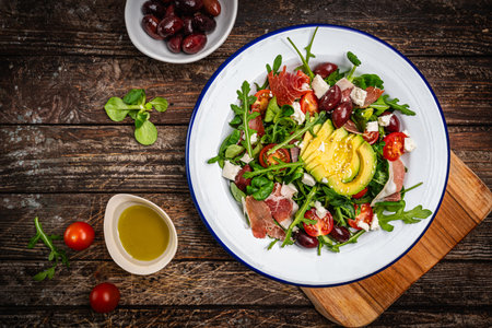 Green salad with avocado, salad leaves and jamon serrano or prosciuttoの写真素材