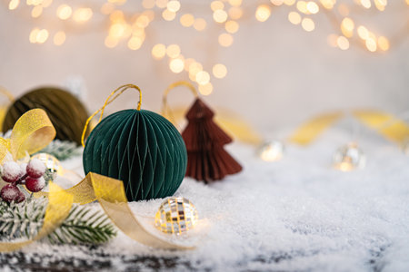 Paper Christmas Ornaments on Snow with Lights and Ribbonの写真素材
