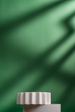 Minimal white podium on green background with natural shadowsの写真素材