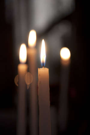 Candles glowing in the church. Shallow depth of field.の写真素材