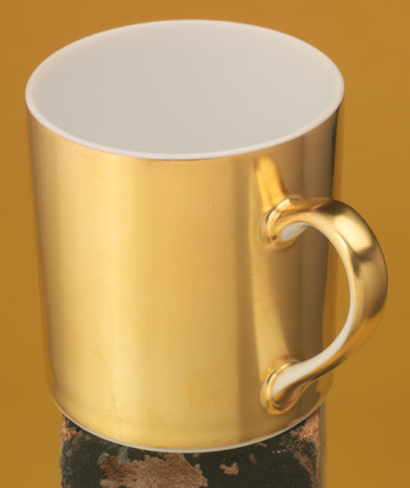 Golden coffee cup isolated on a yellow backgroundの写真素材