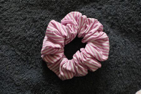 pink striped scrunchie on grey fabric
