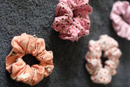 assortment of pink scrunchies on dark grey clothの写真素材
