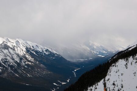 Snow capped mountains against a cloudy sky