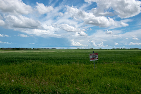 Mosaic Sign warning of open pit exploration in a field, west of Churchbridge, Saskatchewan, Canada.のeditorial素材