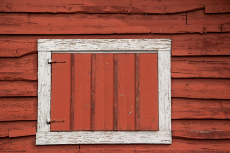White framed hay loft door on an old red barn.の写真素材