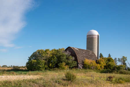 Abandoned farm yard with barn and silo.の写真素材