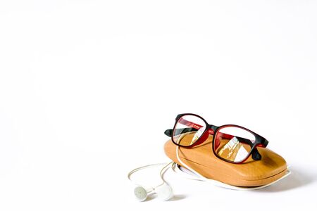 red framed eyeglass placed on its wooden case on white backgroundの写真素材