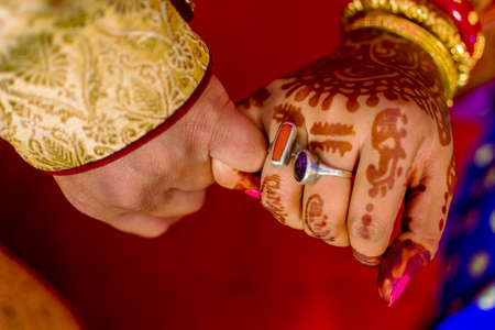 newly wedded couple crossing their little fingers for pinky swearの写真素材