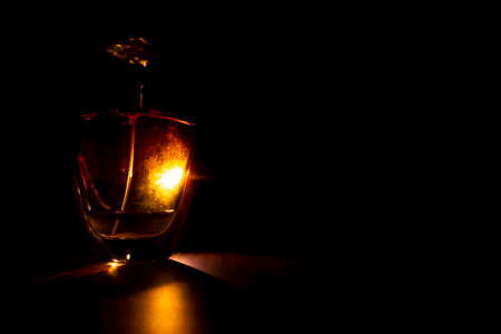 High class perfume bottle isolated on dark background with backlitの写真素材