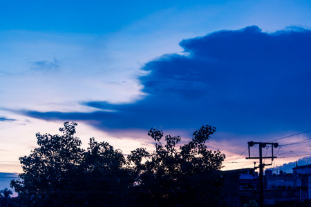 Orange, yellow, pink, purple, blue colors play on the cloudy city sky at sunset