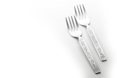 Vintage engraving silverware fork set of two placed side by side isolated right side on white...