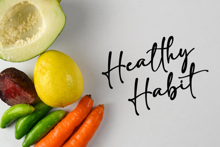 Promoting healthy living, this image features fresh produce including avocado, lemon, and carrots displayed creatively with hand-lettered text.の写真素材