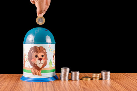 A colorful piggy bank with a lion illustration holds coins, symbolizing savings, financial planning,...