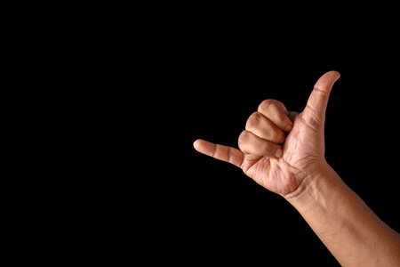 Hand demonstrating the iconic shaka gesture, symbolizing aloha spirit and friendly vibes.の写真素材