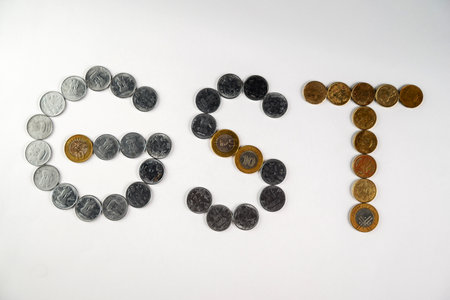 Depiction of monetary coins arranged to form the acronym 'GST,' symbolizing the financial and taxation concept related to the Goods and Services Tax policy.の写真素材