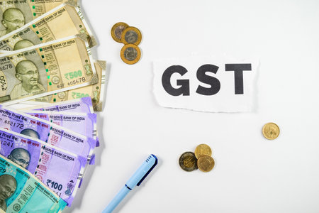 Top view of a collection of Indian currency notes and coins displayed beside a GST sign, symbolizing...