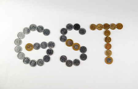 Depiction of monetary coins arranged to form the acronym 'GST,' symbolizing the financial and...