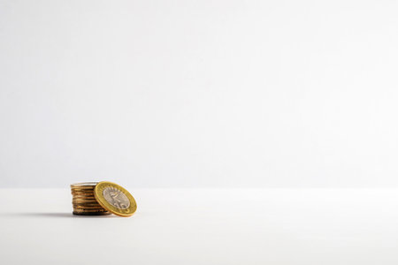 A neat stack of gold coins displayed on a plain white surface, symbolizing financial concepts like savings, investments, and currency. This minimalist composition portrays simplicity and monetary values.の写真素材